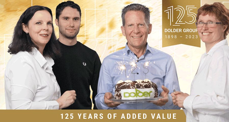 Four people stand together celebrating, one holding a cake with sparklers and the word “Dolder.” A banner reads “125 years of added value” with “125 Dolder Group 1898–2023” in the background.