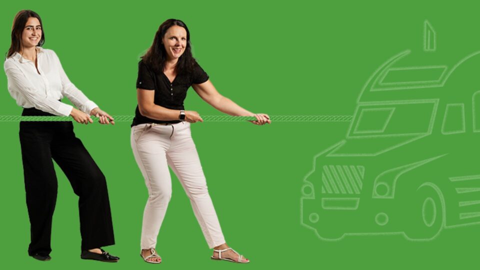 Two women pulling on a rope against a green background with a white outline drawing of a truck at the other end of the rope.